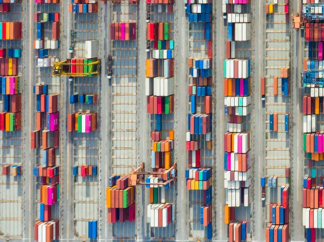Sparse rows of shipping containers sit at a port